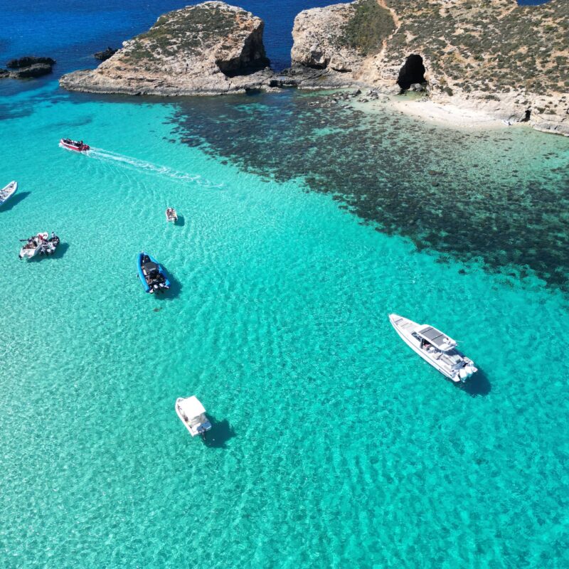 Private boat charter in the Blue Lagoon, Malta, surrounded by crystal blue waters and calm conditions ideal for swimming and relaxing.