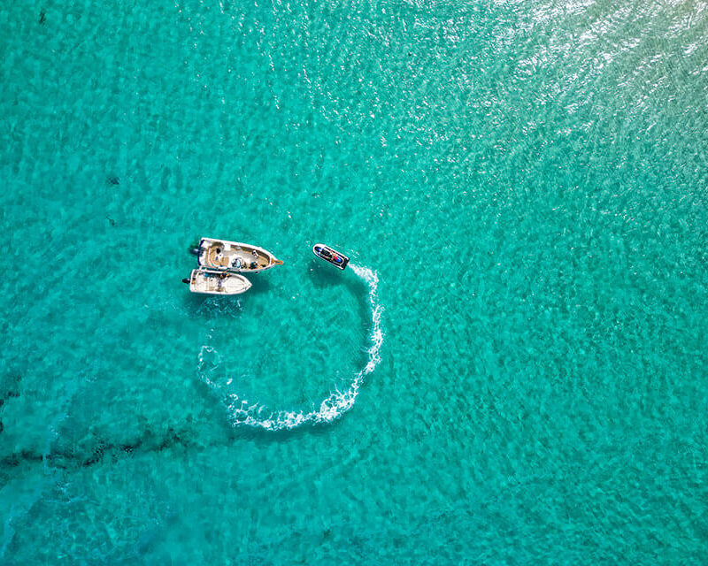 Jet ski and boat in the Blue Lagoon, Comino, with crystal blue water and no people, showing calm early conditions.