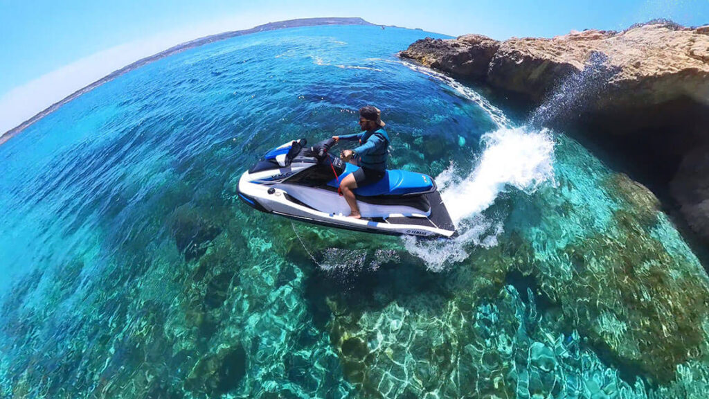 A man rides a jet ski on a guided safari tour in Malta, exploring crystal-clear waters, hidden caves, and scenic coastlines.