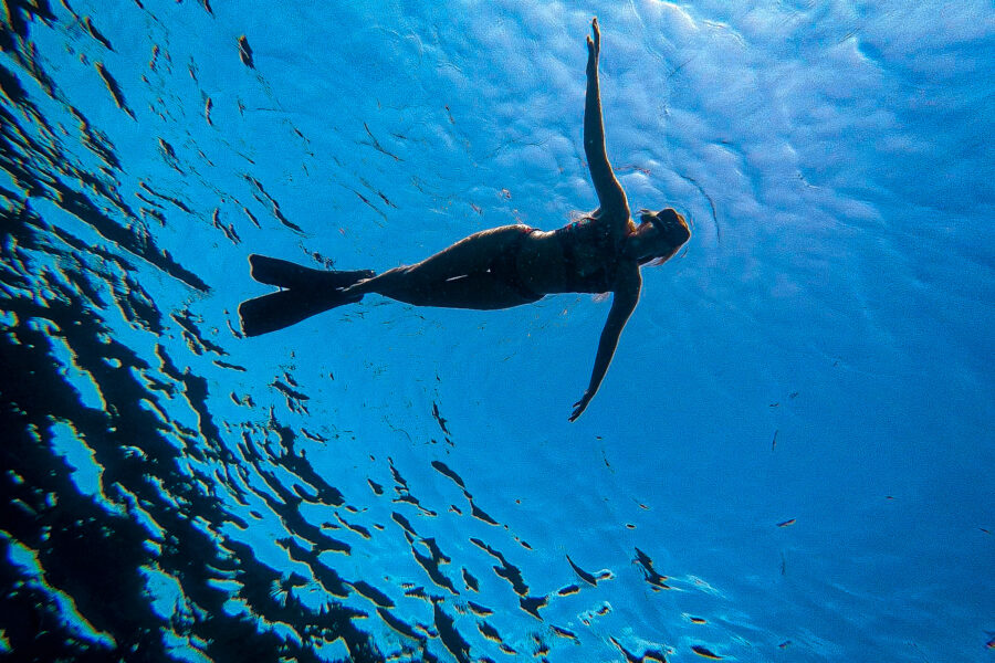 Snorkeling in crystal-clear blue waters during a private boat trip to Comino, exploring vibrant marine life and hidden underwater spots.