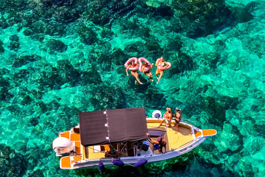 Boat in the Crystal Lagoon in Comino, Malta, with people having fun in clear blue water during a relaxed private boat tour.