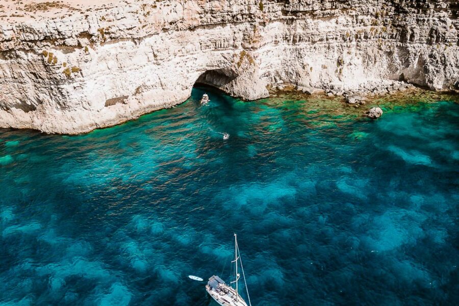 Boat tour at the Crystal Lagoon in Malta with deep blue water and limestone cliffs, enjoyed during a calm and scenic private boat experience.