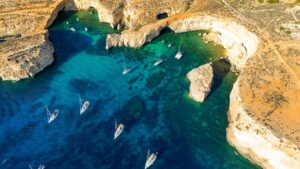 Crystal Lagoon in Comino, Malta, showing deep blue water and limestone cliffs during a calm private boat tour experience.
