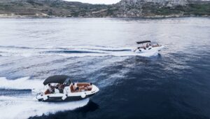Fast boat cruising between Malta, Comino, and Gozo, cutting through clear blue water during an exciting private boat tour.