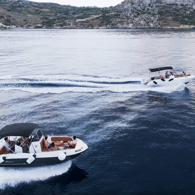 Fast boat cruising between Malta, Comino, and Gozo, cutting through clear blue water during an exciting private boat tour.