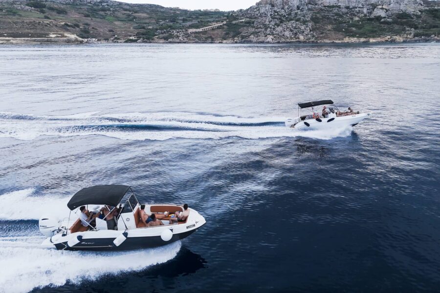 Fast boat cruising between Malta, Comino, and Gozo, cutting through clear blue water during an exciting private boat tour.