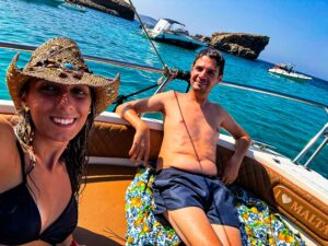 Happy couple enjoying time on a private boat in Malta, surrounded by calm blue water during a relaxed and romantic boat tour.