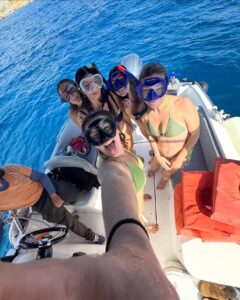 Ladies party snorkelling off a private boat in Malta, enjoying clear blue water during a fun and relaxed group boat tour.