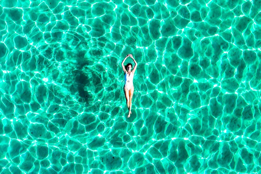 Lady floating in crystal blue water at the Blue Lagoon in Comino, Malta, capturing a perfect, calm moment during a private boat tour.