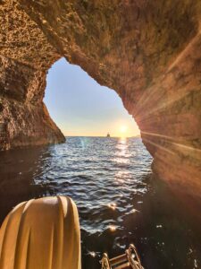 Lover’s Cave in Comino at sunset during a private boat tour, with calm blue water, warm evening light, and a romantic atmosphere.
