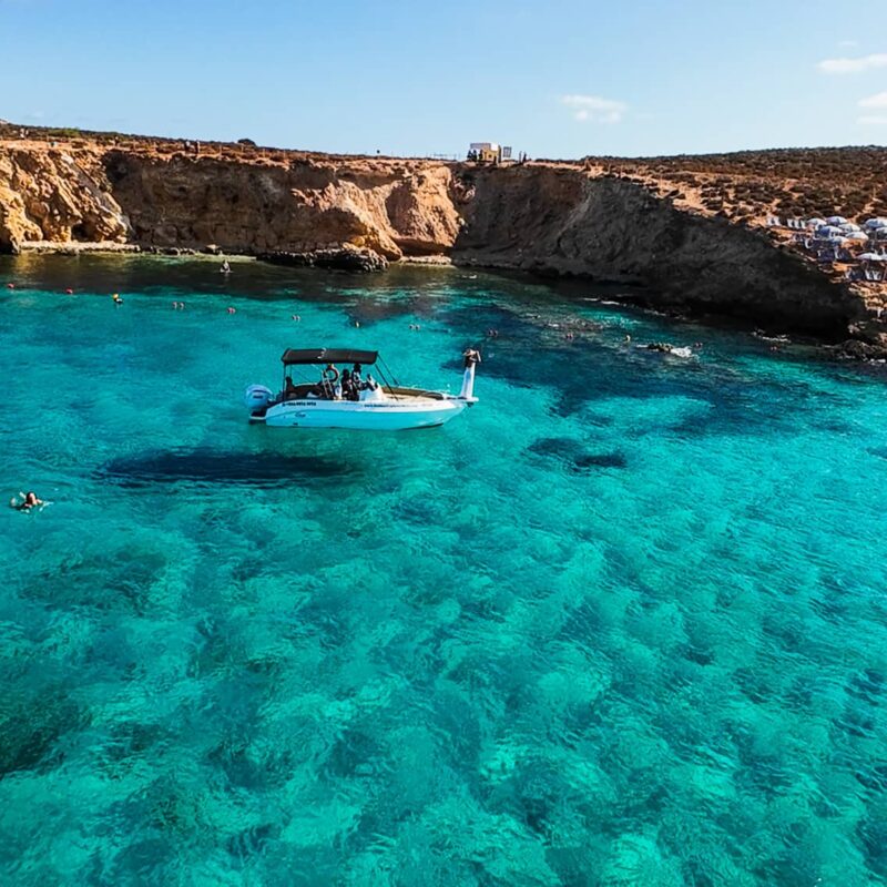 Luxury private boat at the Blue Lagoon in Malta, surrounded by crystal blue water and calm conditions during a relaxed boat charter experience.