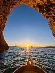 Romantic sunset moment inside a sea cave in Comino, Malta, experienced by private boat with calm blue water and peaceful surroundings.