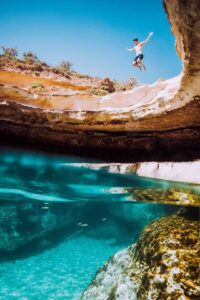 guy jumping st peters pool malta cliff diving crystal clear water marsaxlokk summer swimming