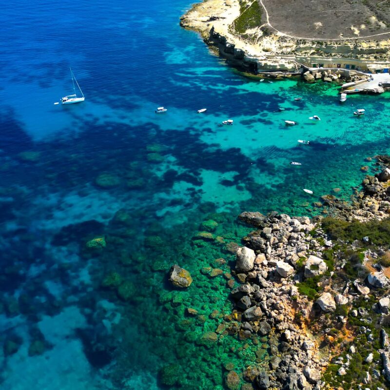 Private boat charter exploring the scenic limestone cliffs and clear waters of Daħlet Qorrot Bay in Gozo Malta.