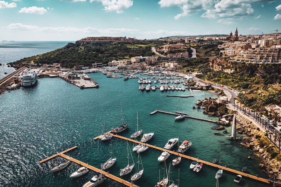 Boats docked at Mġarr Harbour Marina in Gozo Malta, a primary departure point for private boat charters to Comino and the Blue Lagoon.