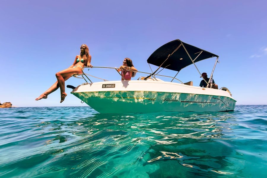 Private boat rental cruising through crystal-clear blue water near Comino’s Blue Lagoon, Malta